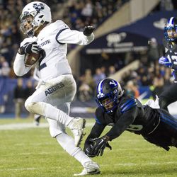 Utah State quarterback Kent Myers (2) evades a Brigham Young tackler during an NCAA college football game against Brigham Young in Provo on Saturday, Nov. 26, 2016.
