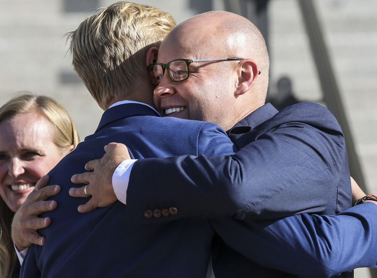 Republican Jeff Burningham, right, embraces his son Truman Burningham, 15, after announcing his candidacy for Utah governor on the steps of the state Capitol in Salt Lake City on Tuesday, Sept. 10, 2019.