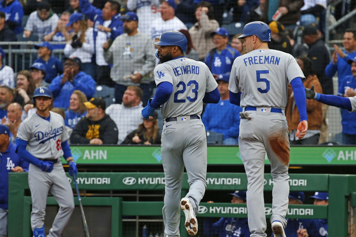 Jason Heyward and Freddie Freeman of the Los Angeles Dodgers scores from a two-RBI double in the first inning against the Pittsburgh Pirates at PNC Park on April 25, 2023 in Pittsburgh, Pennsylvania.