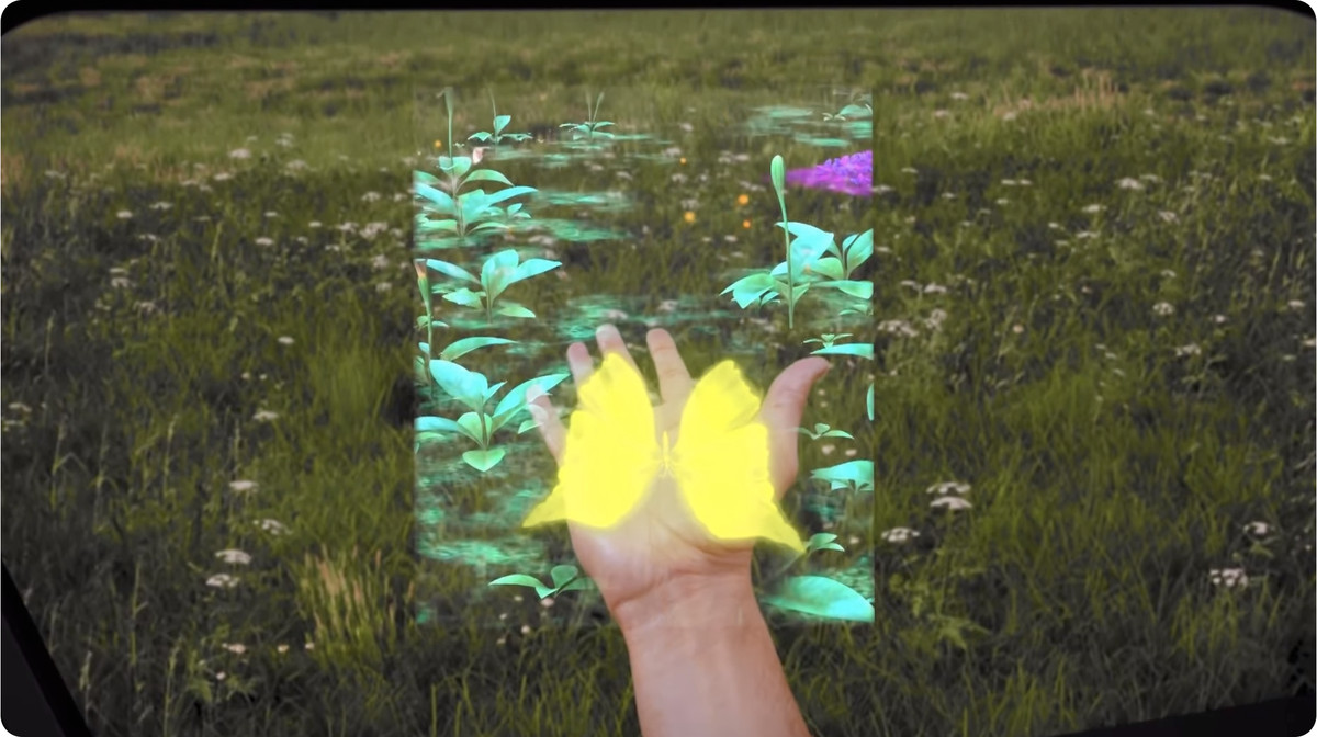 A first-person look through Spectacles showing an area in the center augmented with glowing plants and a butterfly landed on the wearer’s palm.