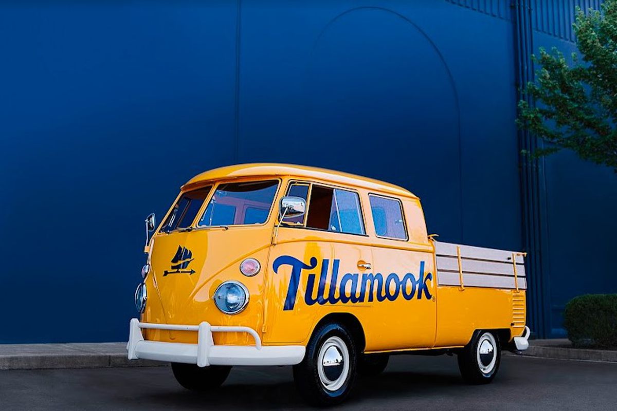 A vintage-style, cheddar cheese-colored Volkswagen bus with “Tillamook” emblazoned on the side.