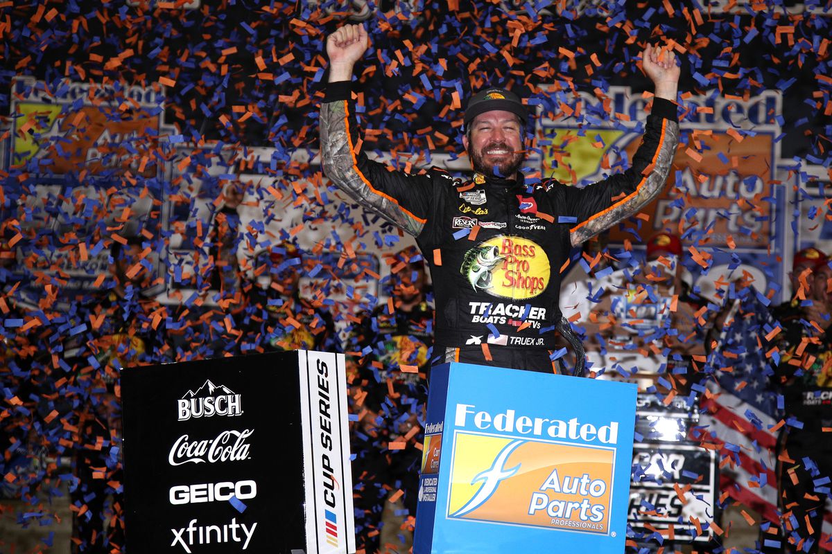 Martin Truex Jr., driver of the #19 Bass Pro Shops Red White Blue Toyota, celebrates in the Ruoff Mortgage victory lane after winning the NASCAR Cup Series Federated Auto Parts 400 Salute to First Responders at Richmond Raceway on September 11, 2021 in Richmond, Virginia.