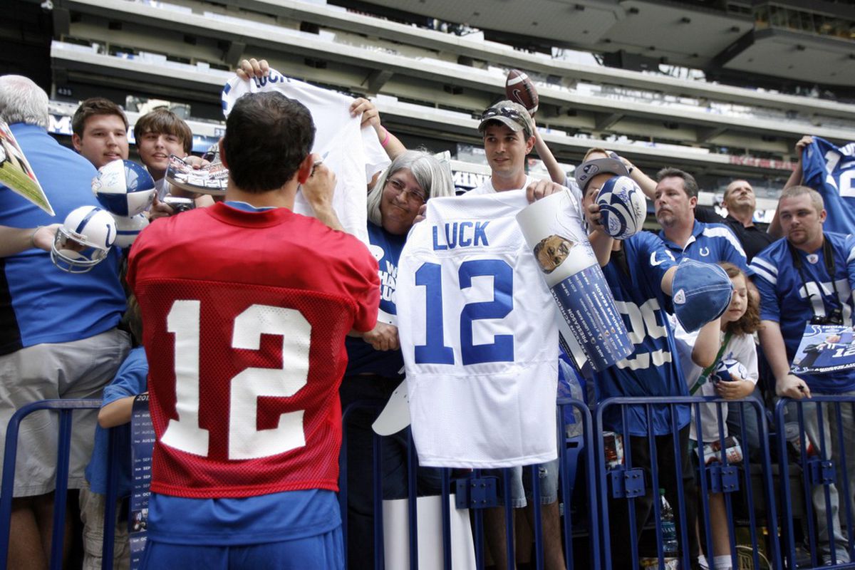 June 13, 2012; Indianapolis, IN, USA; Indianapolis Colts quarterback Andrew Luck (12) signs autographs after minicamp practice at Lucas Oil Stadium. Mandatory Credit: Brian Spurlock-US PRESSWIRE