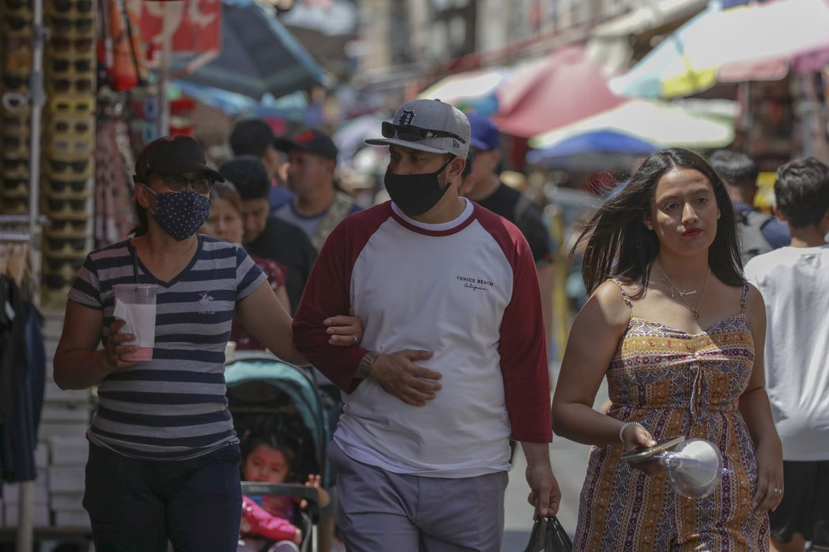 Pembeli bermasker dan tanpa masker di pasar Santee Alley yang sangat padat pada Kamis, 14 Juli 2022 di Los Angeles, CA.