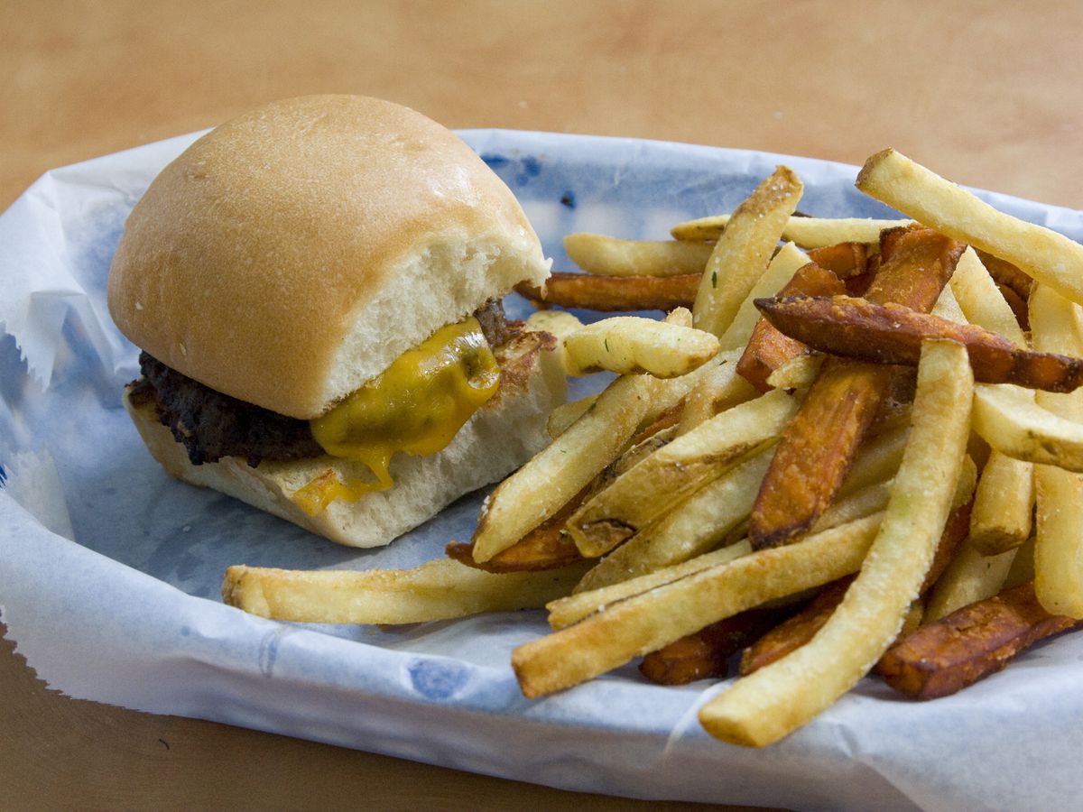 A slider burger with fries on a tray.