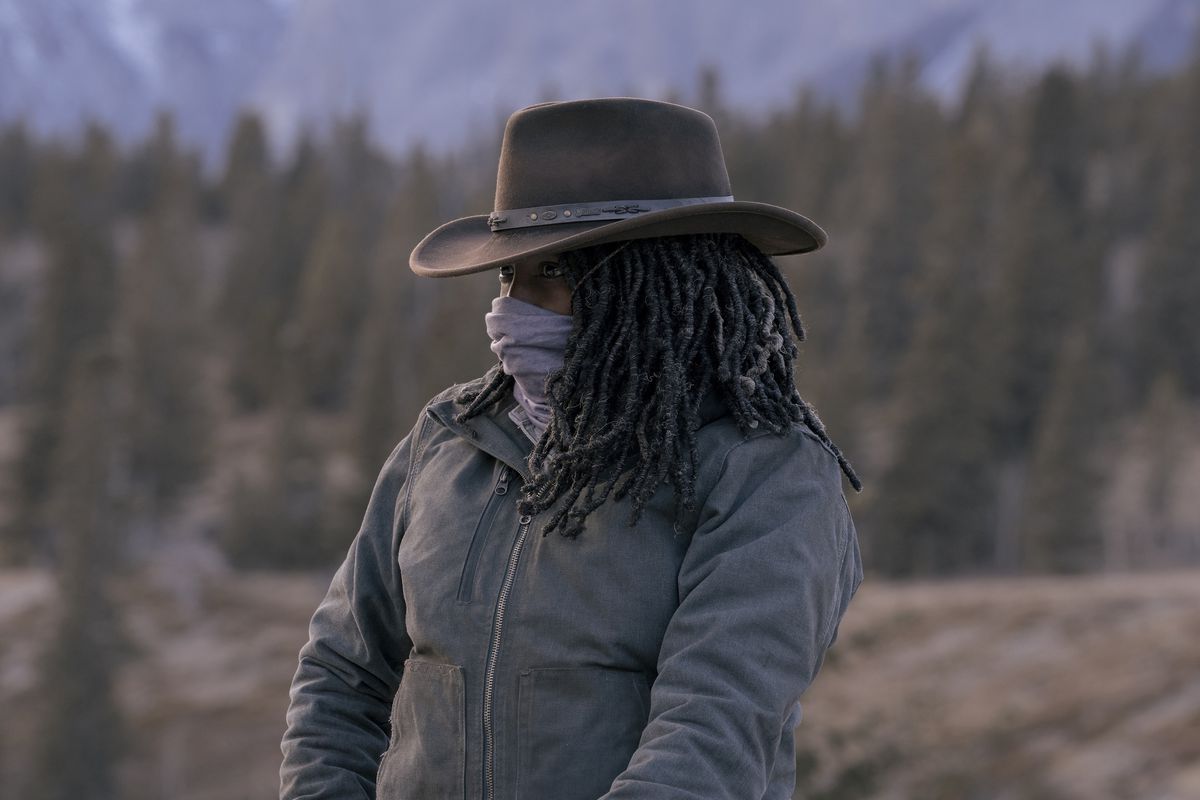 Maria (Rutina Wesley) looking at something off-screen with a cowboy hat and her balaclava pulled over her nose so only her eyes are visible