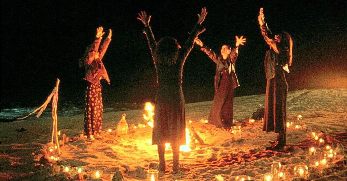 un grupo de cuatro chicas alrededor de un círculo de invocación ardiente