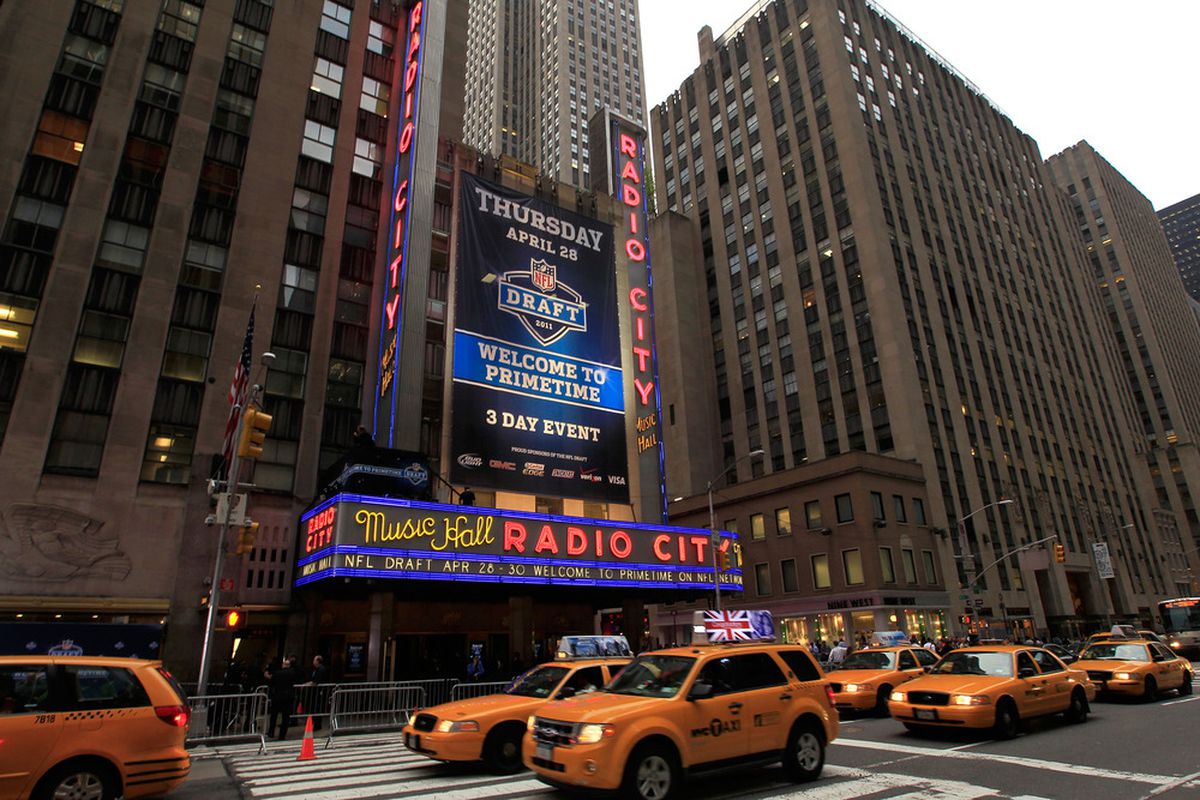 NEW YORK, NY - APRIL 28:  Taxi cabs drive down the Avenue of the Americas past the Radio City Music Hall marquee, site of the 2011 NFL Draft, on April 28, 2011 in New York City.  (Photo by Chris Trotman/Getty Images)