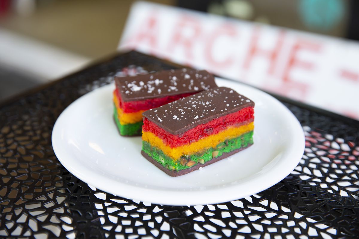 Two rainbow cookies displayed on a plate.