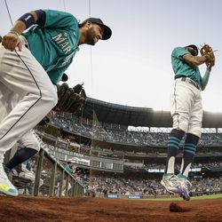 Eugenio Suarez #28 and J.P. Crawford #3 of the Seattle Mariners take the field before the game against the Oakland Athletics