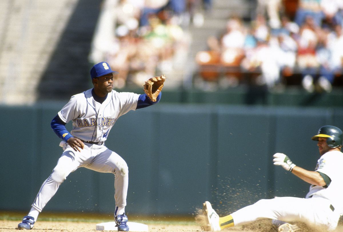 CIRCA 1991: Harold Reynolds #4 of the Seattle Mariners takes the throw down at second base against the Oakland Athletics during a Major League Baseball game circa 1991 at the Oakland-Alameda County Coliseum in Oakland, California. Reynolds played for the Mariners from 1983-92.  
