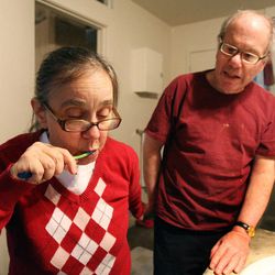Martin Personick helps his wife, Valerie, who has Alzheimer's, to brush her teeth at their apartment in Salt Lake City, Thursday, Oct. 18, 2012. Martin receives help from Homewatch CareGivers in caring for Valerie.
