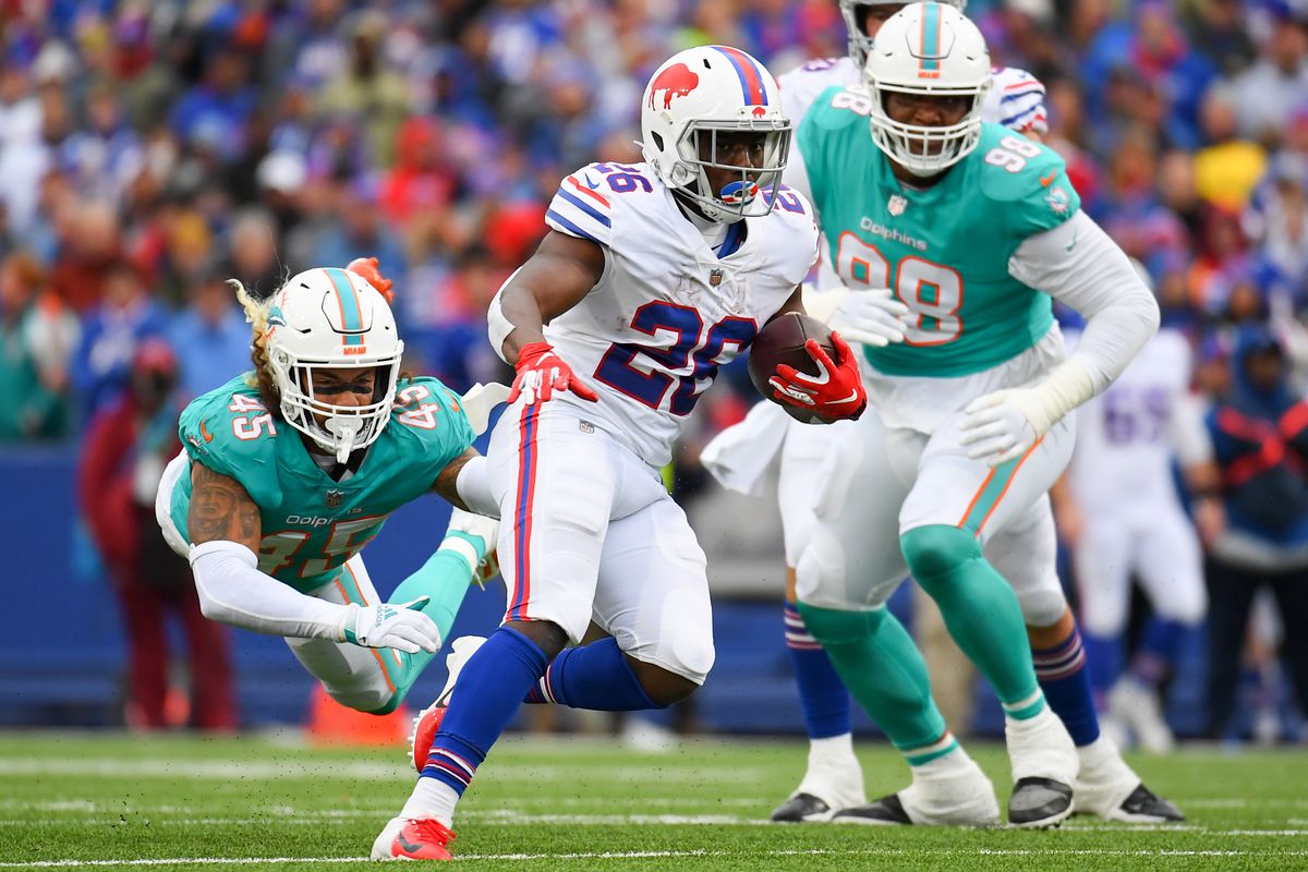 Buffalo Bills running back Devin Singletary (26) runs with the ball as Miami Dolphins middle linebacker Duke Riley (45) goes airborne on a tackle attempt during the second half at Highmark Stadium.&nbsp;