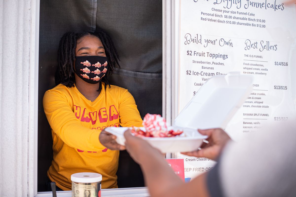 Fun Diggity owner Cheyenne Brown delivers funnel cake to a customer in Compton, California.