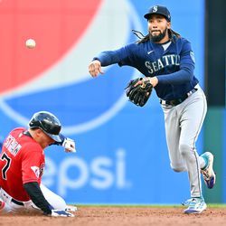 Shortstop J.P. Crawford #3 of the Seattle Mariners throws the ball to first as Myles Straw #7 of the Cleveland Guardians is out at second for a double play during the third inning of the game at Progressive Field on April 08, 2023 in Cleveland, Ohio.