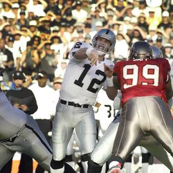 Jan 26, 2003; San Diego, CA, USA; FILE PHOTO; Oakland Raiders quarterback Rich Gannon (12) throws a pass over Tampa Bay Buccaneers defensive tackle Warren Sapp (99) during Super Bowl XXXVII at Qualcomm Stadium. The Bucs defeated the Raiders 48-21. Mandato