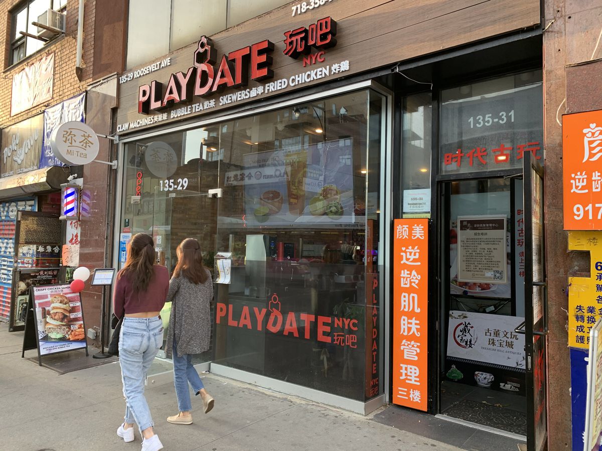 The exterior of a restaurant called playdate, with people seen walking on the sidewalk