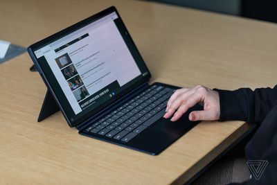 A user browses the Lenovo Chromebook Duet 5 in a conference room.