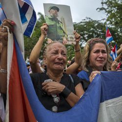 Women weep as the procession carrying the ashes of Cuba's leader Fidel Castro leaves the town of Santa Clara, Cuba, Thursday, Dec. 1, 2016. Castro's ashes are in a four-day journey across Cuba from Havana to their final resting place in the eastern city of Santiago. 