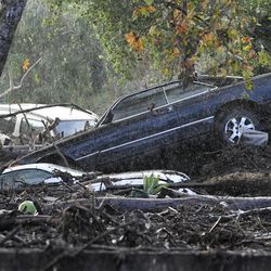 Cars that were washed away are piled up on the banks of Romero Creek in Montecito, Calif., Tuesday, Jan. 9, 2018. Dozens of homes were swept away or heavily damaged Tuesday as downpours sent mud and boulders roaring down hills stripped of vegetation by a gigantic wildfire that raged in Southern California last month. (AP Photo/Michael Owen Baker)
