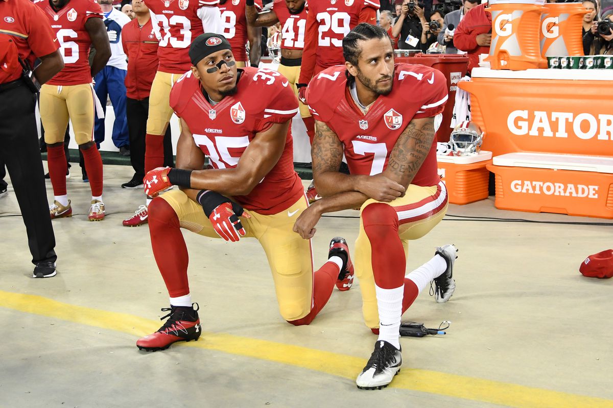 NFL players Eric Reid and Colin Kaepernick kneel during the national anthem.