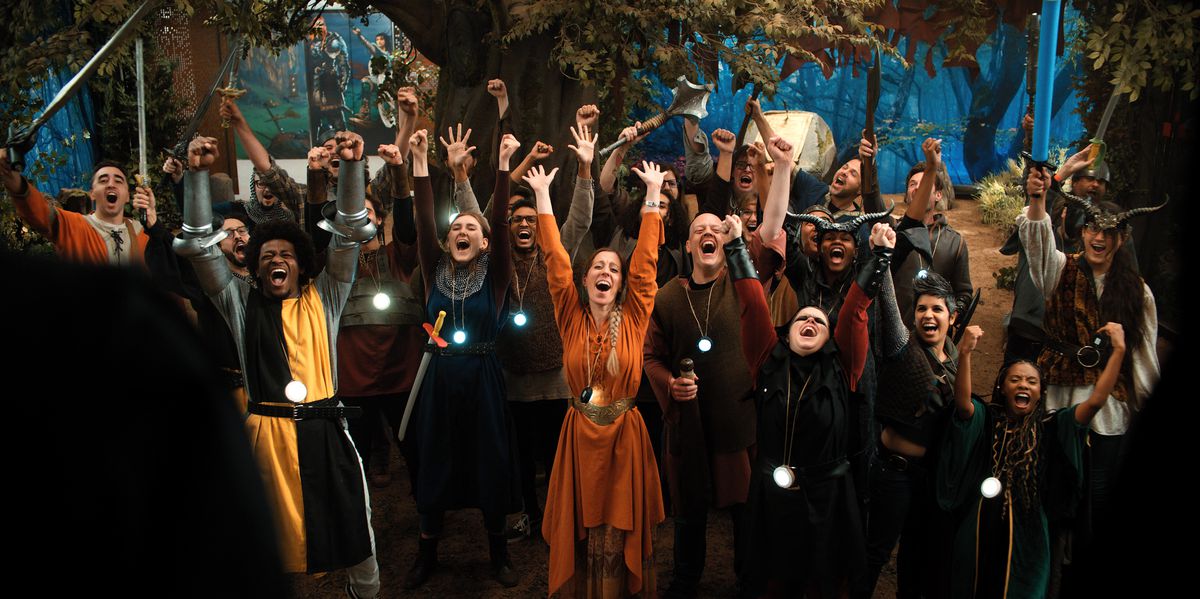 The cast of Mythic Quest in medieval fantasy costumes all cheer.