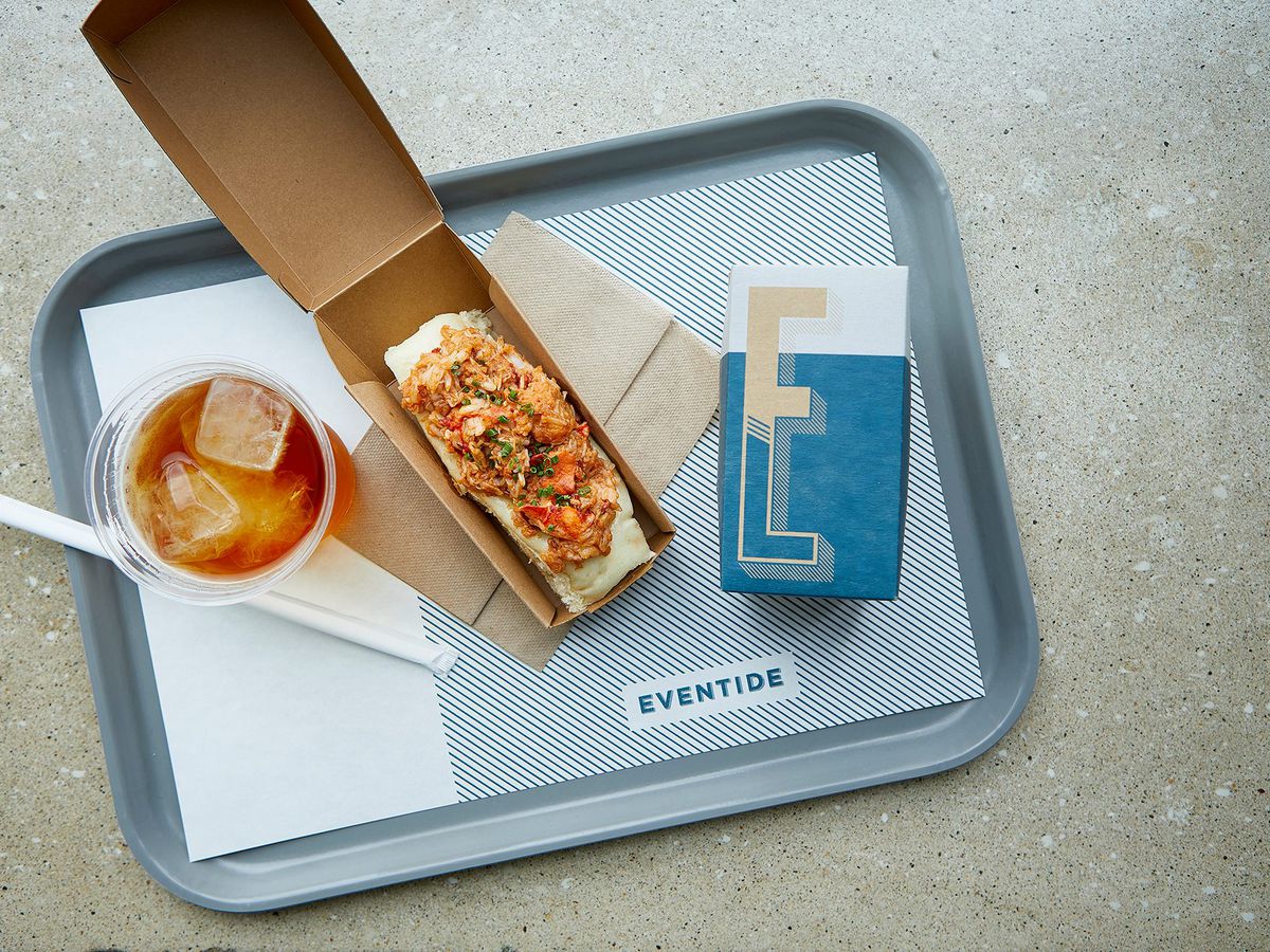 Overhead view of a lobster roll on a blue tray.