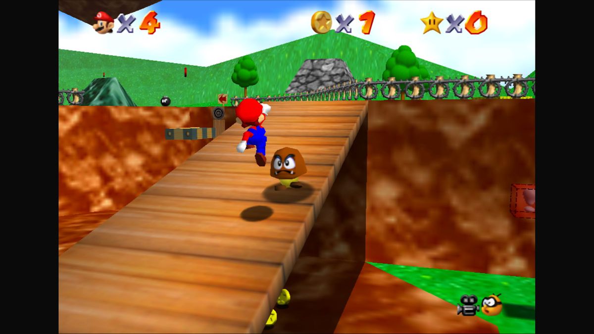 Mario jumps up a ramp, aiming for a goomba, in Super Mario 64