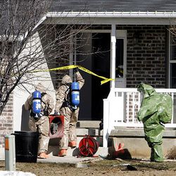 Hazmat teams check the area inside and around the Toone family's home in Layton Monday for phosphine gas.