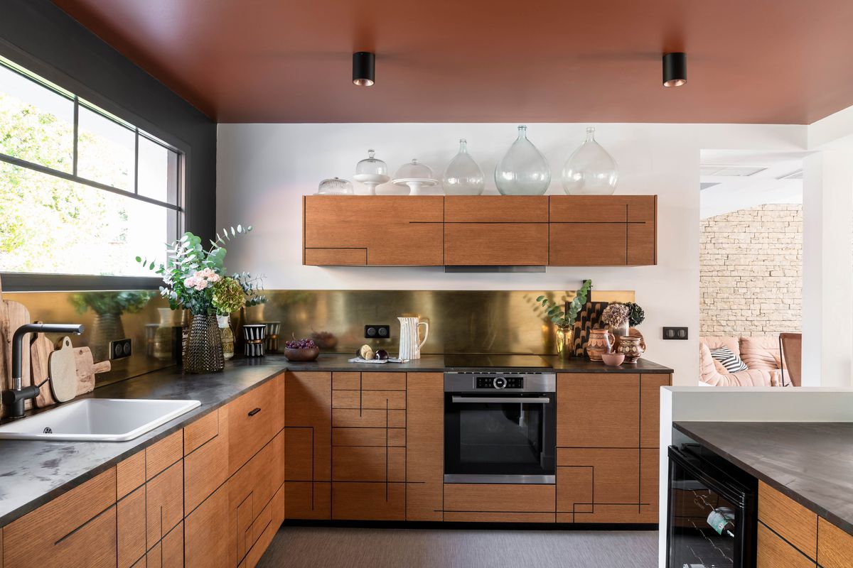 A modern kitchen with a clay colored ceiling. 