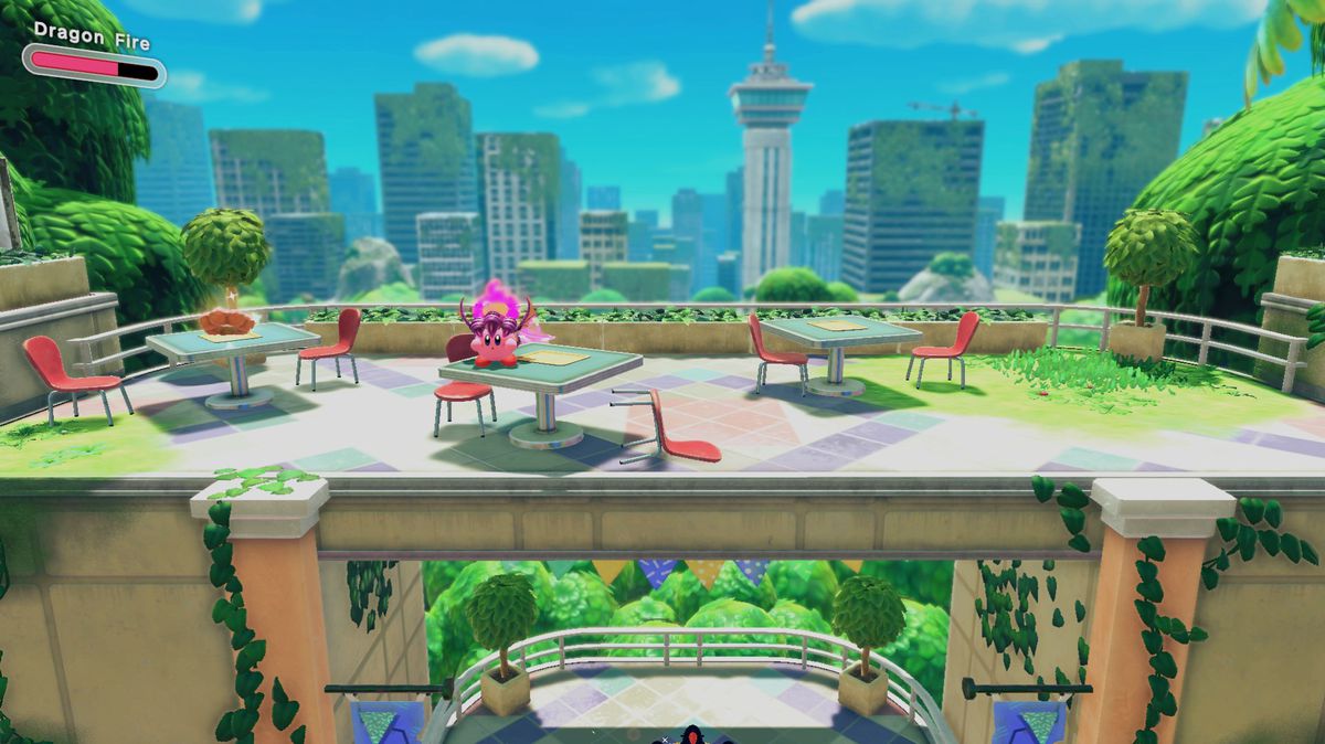 Kirby stands on a table above an arch near a floating doughnut.
