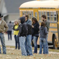 Parents wait for their children as Fremont High School students are evacuated from the school after reports of a student with a gun were made in Ogden Monday, Dec. 1, 2014. 