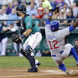 Chicago Cubs' Alfonso Soriano scores ahead of the throw to Seattle Mariners catcher Mike Zunino, left, in the second inning of a baseball game, Friday, June 28, 2013, in Seattle. 