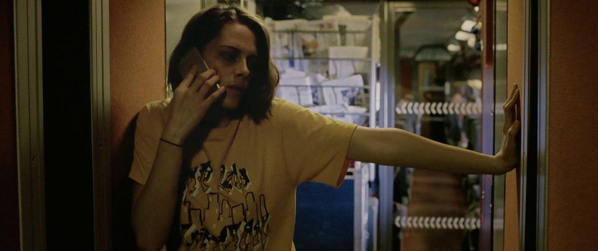 Kristen Stewart se apoya contra una pared mientras habla por teléfono en Personal Shopper.