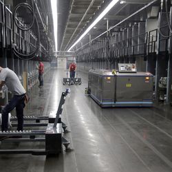 Workers exchange spools of thread as a robot picks up thread made from recycled plastic bottles at the Repreve Bottle Processing Center, part of the Unifi textile company in Yadkinville, N.C., Friday, Oct. 21, 2016.  America has lost more than 7 million factory jobs since manufacturing employment peaked in 1979. Yet American factory production, minus raw materials and some other costs, more than doubled over the same span to $1.91 trillion last year, according to the Commerce Department, which uses 2009 dollars to adjust for inflation. That’s a notch below the record set on the eve of the Great Recession in 2007. And it makes U.S. manufacturers No. 2 in the world behind China. 