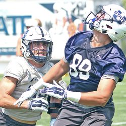 Utah State safety Gaje Ferguson, left, plays tight defense on Aggie tight end Travis Boman during practice Friday afternoon in Logan.