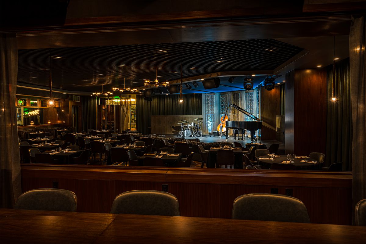 The interior of a dim jazz bar venue with a stage.