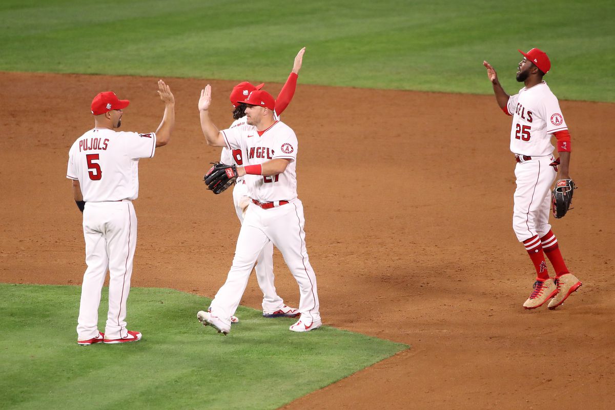 Mike Trout #27, Anthony Rendon #6, Albert Pujols #5, and Dexter Fowler #25 of the Los Angeles Angels celebrate their 4-3 win against the Chicago White Sox after the game on Opening Day at Angel Stadium of Anaheim on April 01, 2021 in Anaheim, California.  &nbsp;   