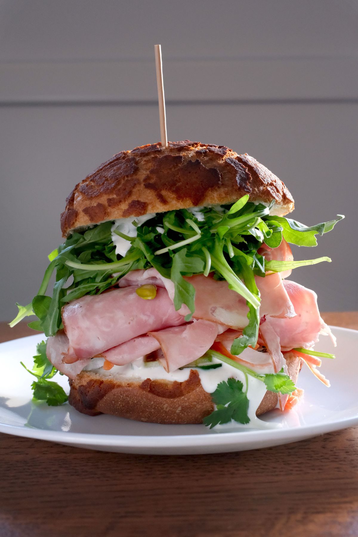 A salami and arugula sandwich on a Dutch crunch roll.