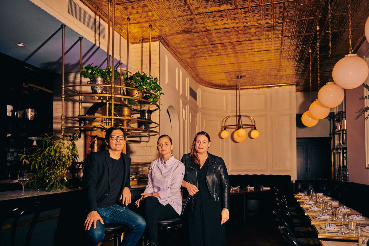 Chef Nikole Morsink (middle) sits on a bar stool between owner Jen Pelka (right) and wine director Jonathan Adkisson (right) in the Riddler dining room before service