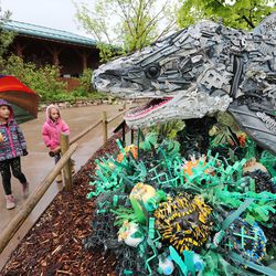 Genevieve and Evangeline Ritchie look at Chompers the Shark, a  sculpture made entirely of plastic garbage found in the oceans, during a visit to Utah's Hogle Zoo in Salt Lake City on Friday, May 24, 2019.