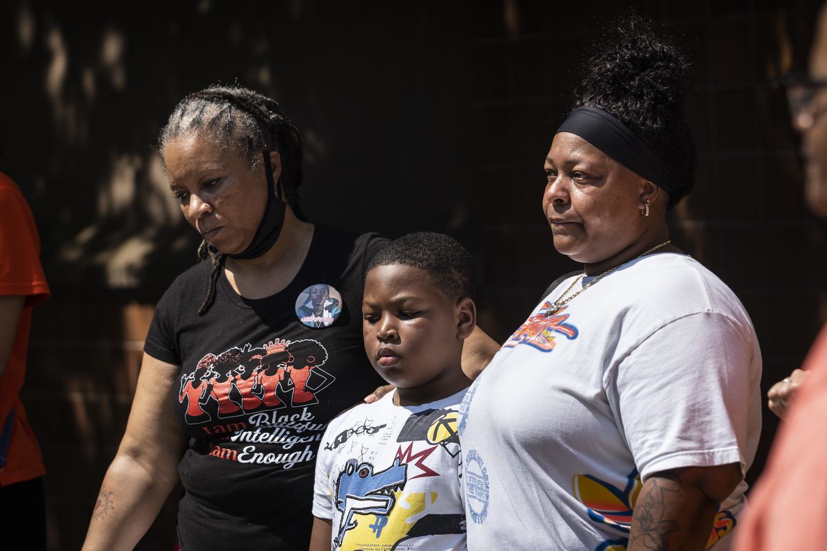 Arewa Karen Winters, great aunt of Pierre Loury, who was killed by Chicago police in April 2016, puts her arm around Cynthia Lane and her 9-year-old grandson as speakers discuss the Chicago Police Department’s new foot pursuit policy during a news conference outside CPD headquarters on the South Side Wednesday morning. Lane’s son, Roshad McIntosh, was killed by Chicago police in August 2014.