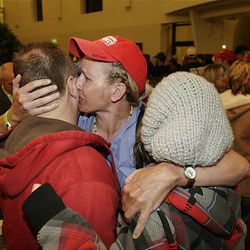 Utah Hospital Task Force member Gaylinn Breeze, West Jordan, kisses husband Tom and daughter Katlyn upon returning to Utah from Haiti.