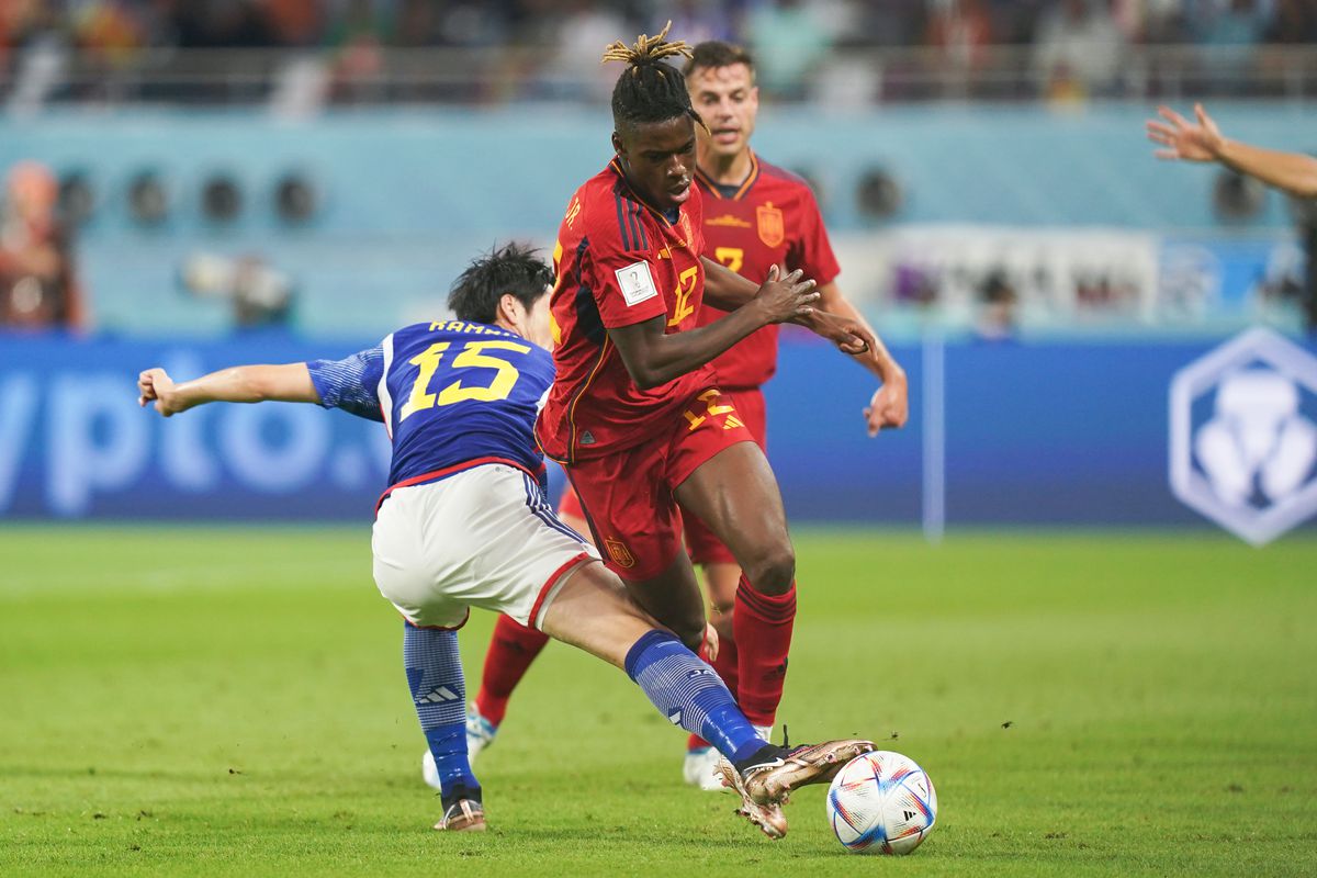 Daichi Kamada (L) of Japan fights for the ball with Nico Williams (R) of Spain during the FIFA World Cup Qatar 2022 Group E match between Japan and Spain at Khalifa International Stadium on December 1, 2022 in Doha, Qatar.