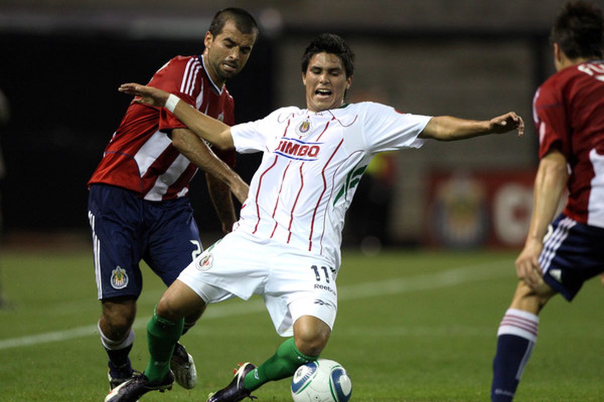 SAN DIEGO CA - SEPTEMBER 14:  Ulises Davila #11 of Chivas Guadalajara is tripped during their ChivasClásico exhibition soccer match against Chivas USA on September 14 2010 at PETCO Park in San Diego California. (Photo by Donald Miralle/Getty Images)