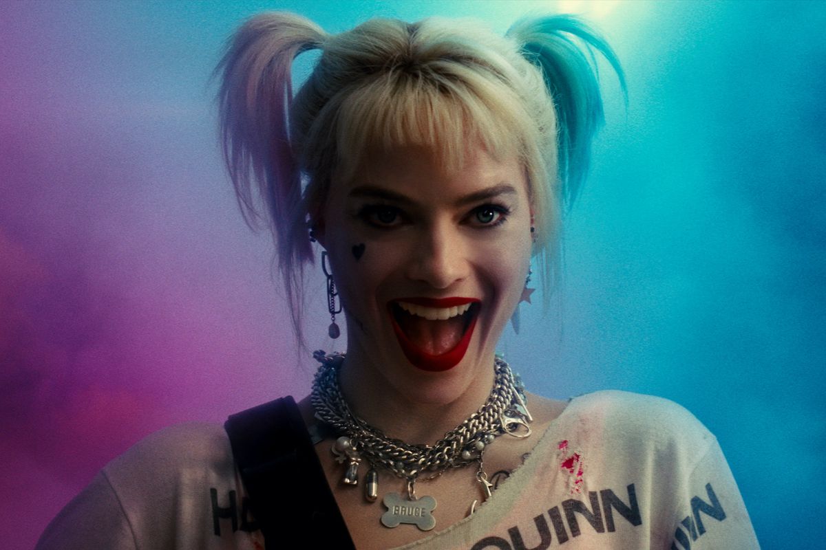 Image: MARGOT ROBBIE grins on a background of purple and blue smoke as Harley Quinn in Warner Bros. Pictures’ “BIRDS OF PREY (AND THE FANTABULOUS EMANCIPATION OF ONE HARLEY QUINN).