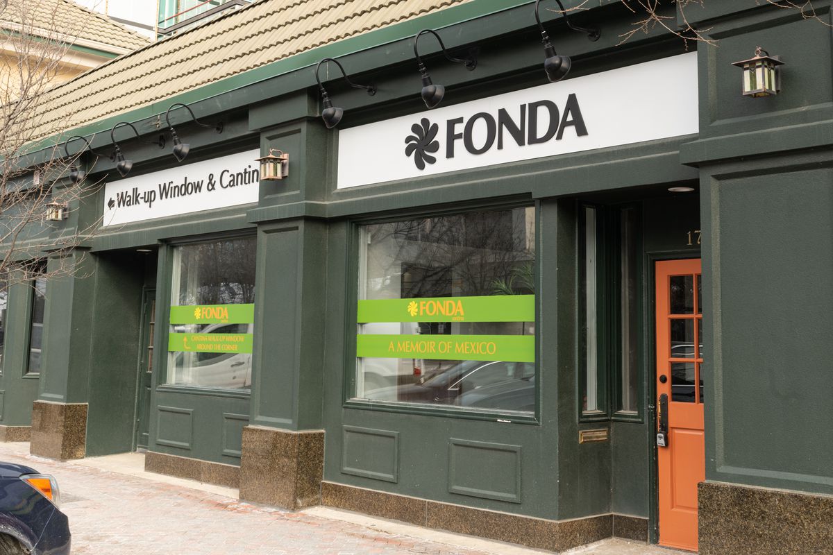 A dark green-painted storefront with a large sign that reads “Fonda” in black letters.