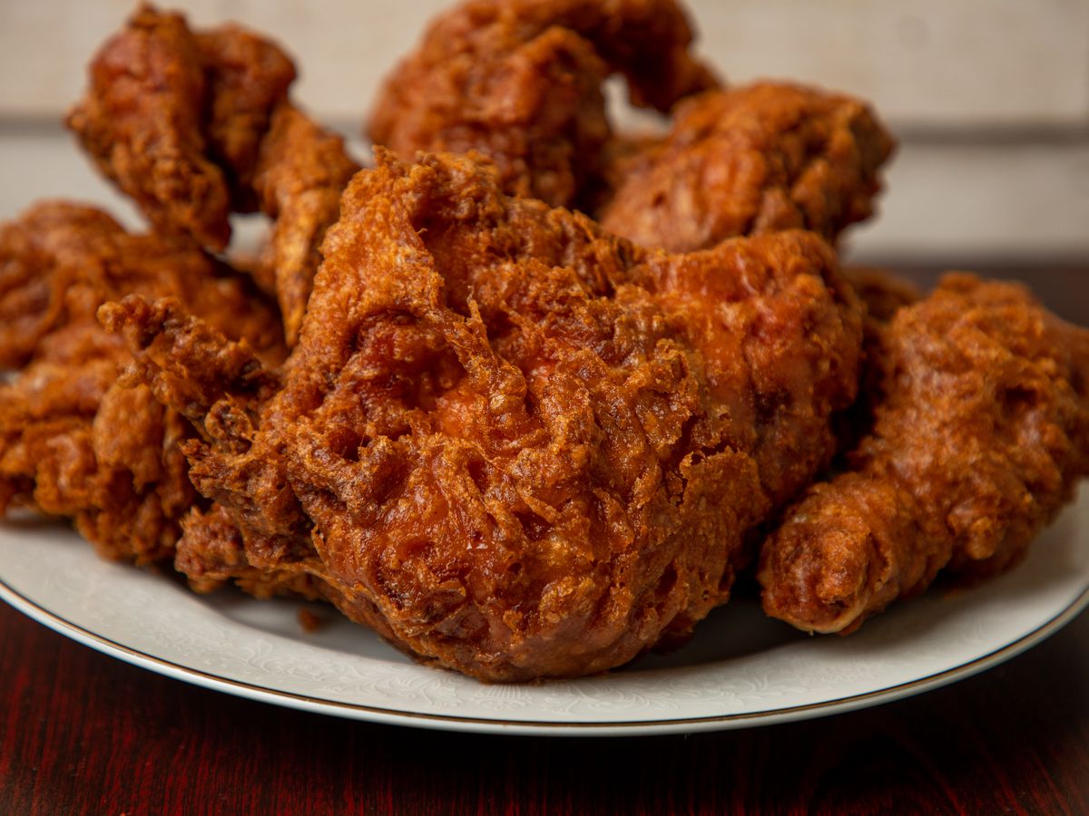 Closeup of a plate of fried chicken thighs and drums.