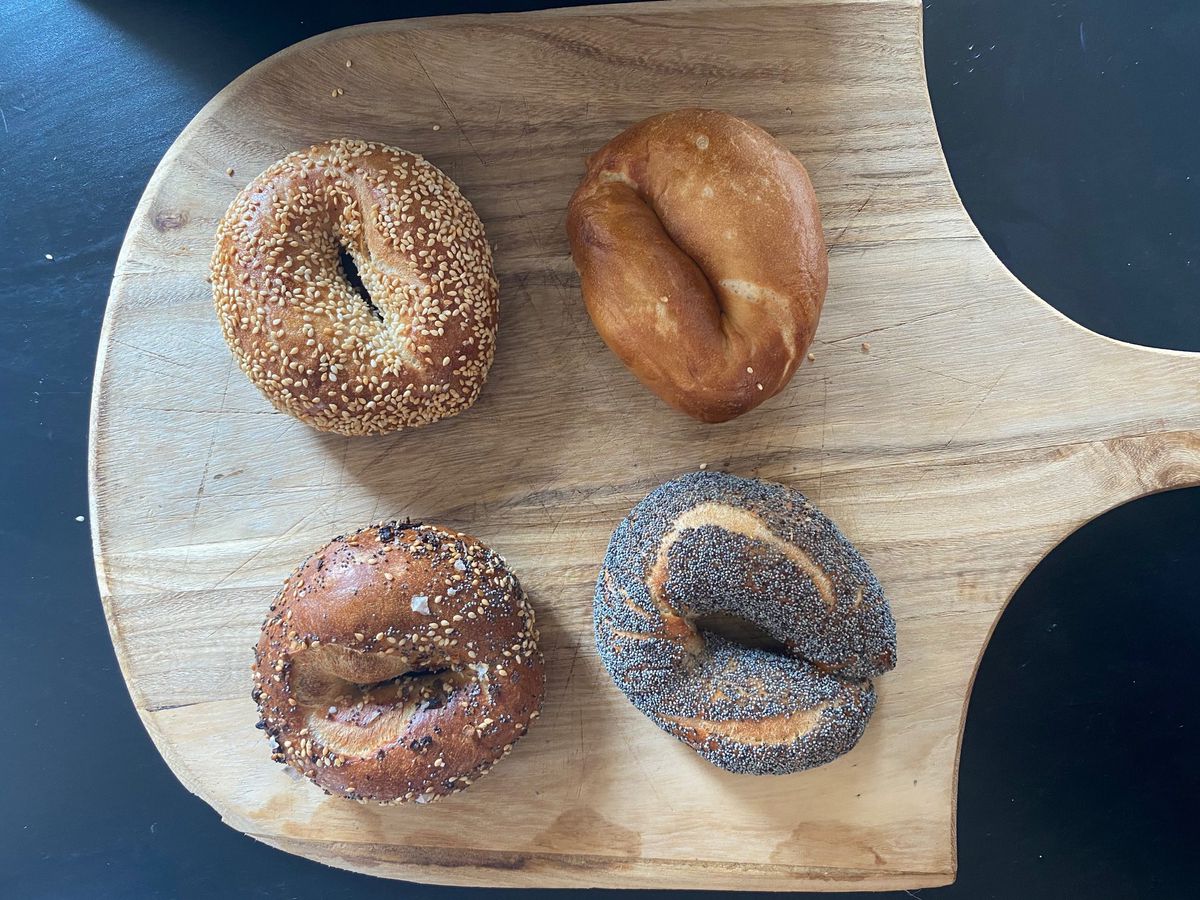 four bagels on a wooden pizza board
