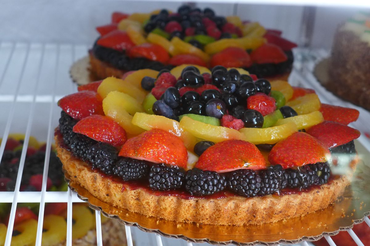A round tart with berries heaped on top.